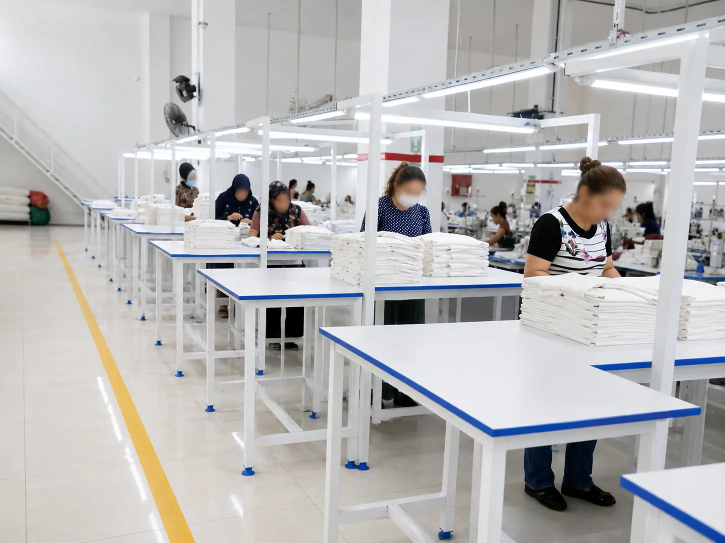 Atelier de confection avec tables de production et vêtements pliés en Turquie
